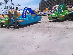 Two candid women topless on beach