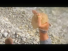 Voyeur on public beach. The suntanned girl rides on the guy