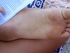 Candid soles at beach - teen studying