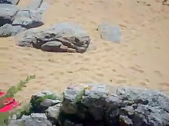 Two nude girls sun bathing on beach.