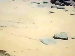 Two nude girls sun bathing on beach.