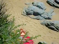 Two nude girls sun bathing on beach.