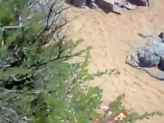 Two nude girls sun bathing on beach.