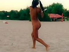 Nude Innuska playing frisbee on the beach