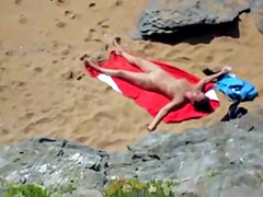 Nude girl on beach sunning.