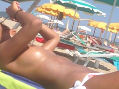 Topless ebony teen on the beach