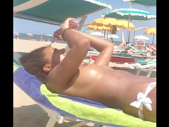 Topless ebony teen on the beach