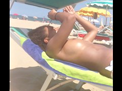 Topless ebony teen on the beach