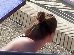 Sexy babe relaxes by the pool