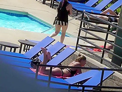 Sexy babe relaxes by the pool