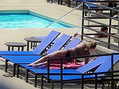 Sexy babe relaxes by the pool