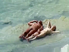Nudist couple sunbathing and refreshing