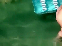 Nudist woman swimming in the beach