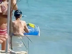 Topless women puts sun cream on face