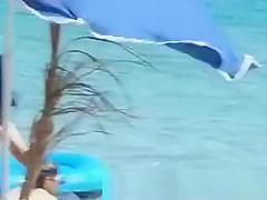 Topless women puts sun cream on face