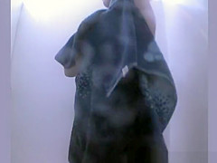 Woman showering and dressing in beach cabin