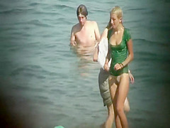 Nudist girl washes a towel in the water