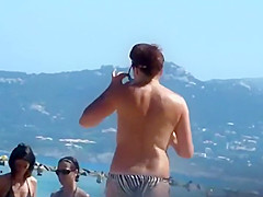 Mature topless woman spied on a beach