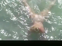 Nude mature woman refreshing in the water