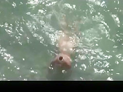 Nude mature woman refreshing in the water