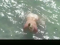 Nude mature woman refreshing in the water