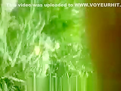 Woman sunbathing topless in grass