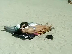 Woman removes her bikini on a beach