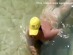 Mature nudist with yellow hat on her head