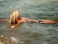 Guy splashes a topless girl with water