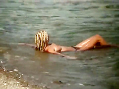 Guy splashes a topless girl with water