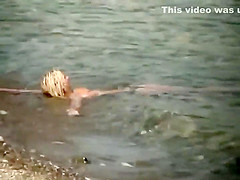 Guy splashes a topless girl with water
