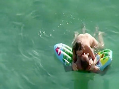 Nudist brunette swims in the water