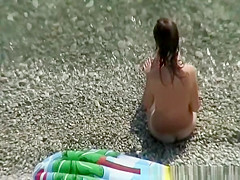 Nudist brunette swims in the water