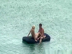 Group of nudist in air mattress in the water