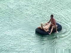 Group of nudist in air mattress in the water