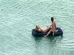 Group of nudist in air mattress in the water