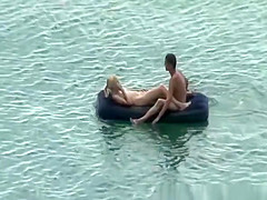 Group of nudist in air mattress in the water