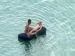 Group of nudist in air mattress in the water
