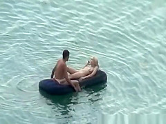 Group of nudist in air mattress in the water