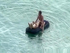 Group of nudist in air mattress in the water
