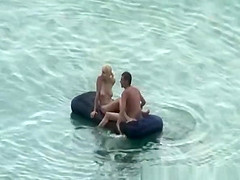 Group of nudist in air mattress in the water