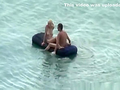 Group of nudist in air mattress in the water