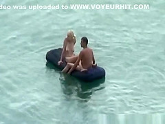Group of nudist in air mattress in the water
