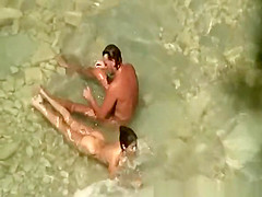 Nudist couple in water at beach