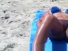 Busty woman sunbathing in bikini