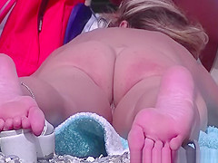 Nudist woman laid down on her belly sunbathing