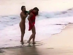 Beautiful naked brunettes splash around in the ocean
