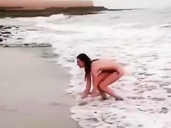 Beautiful naked brunettes splash around in the ocean