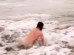 Beautiful naked brunettes splash around in the ocean