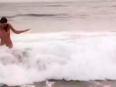 Beautiful naked brunettes splash around in the ocean